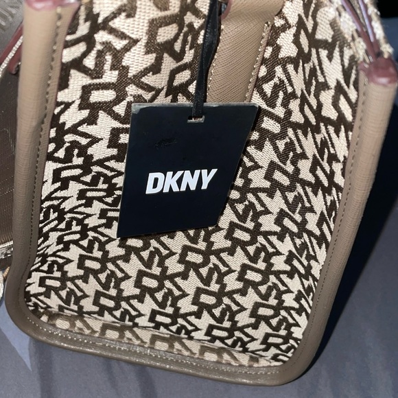 This bag is Tan and brown with a strap, one zipper, two pockets, space inside.